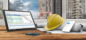 tablet, smartphone, safety helmet and blueprints in construction site