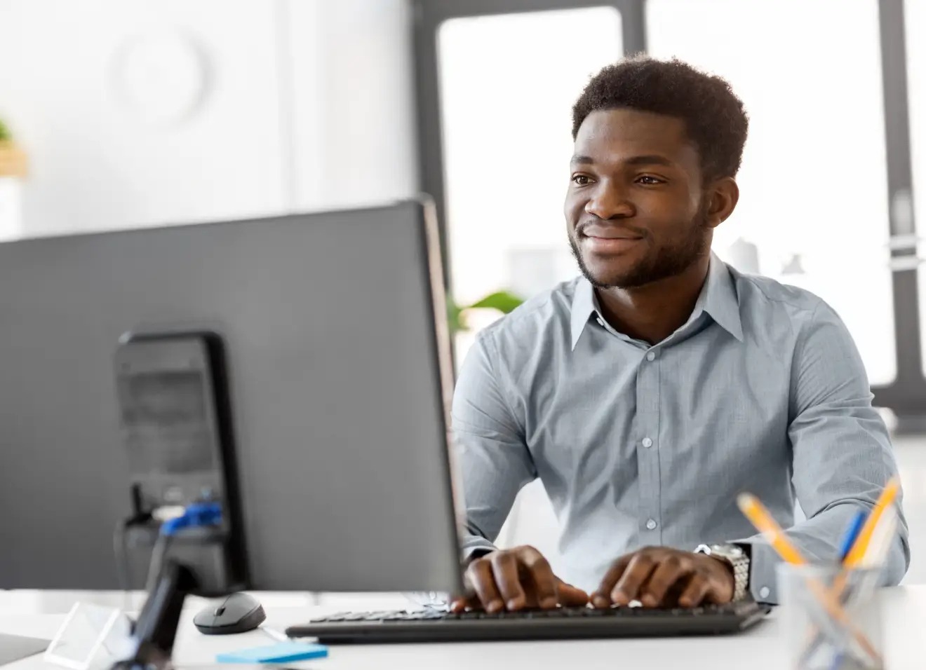 primavera-p6-training-online Man working at a desktop computer in an office environment.